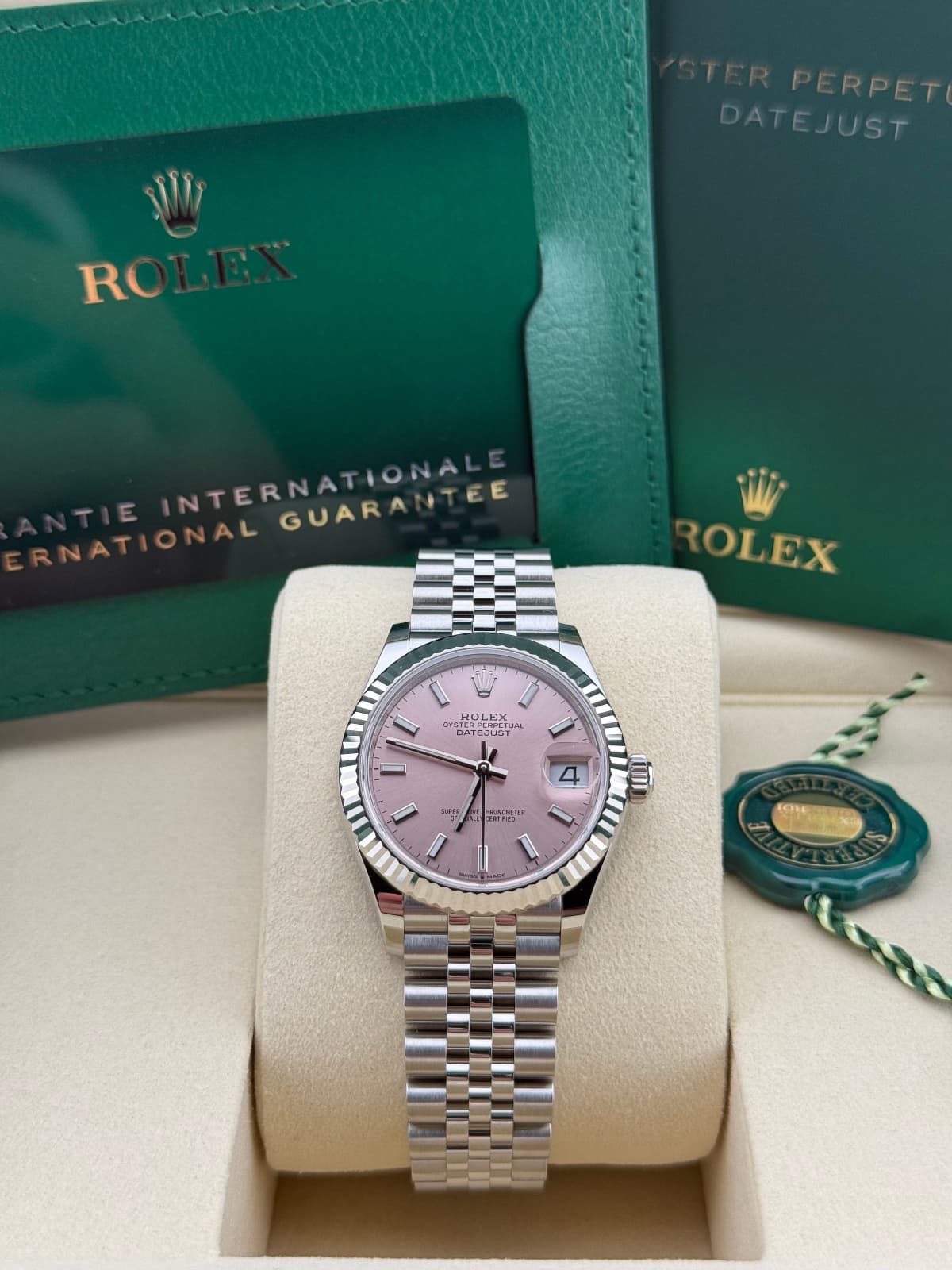 Rolex Datejust 31 Pink Jubilee 278274 - watch with pink face and silver case on a white stand, with Rolex branding in the background.
