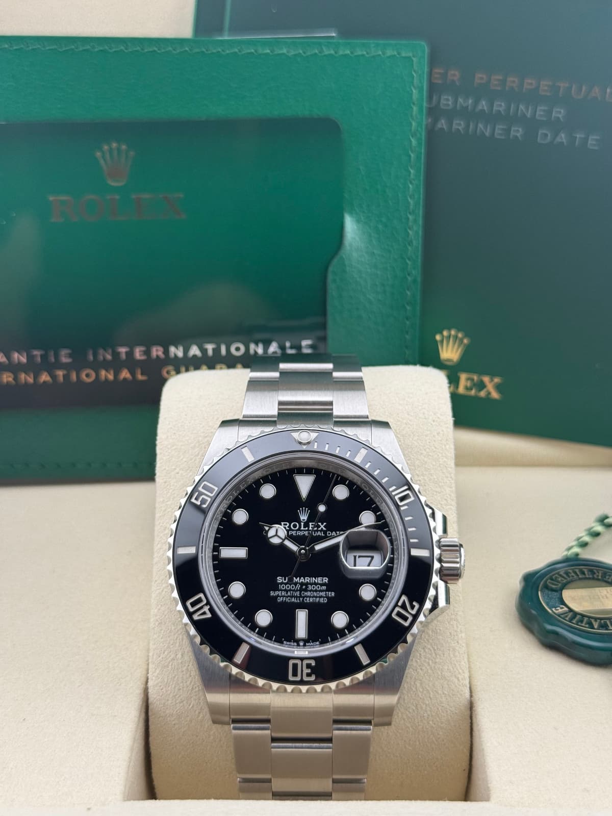 Rolex Sky-Dweller Blue Oyster 326934 - watch with black dial and silver case on beige cushion, green box in background