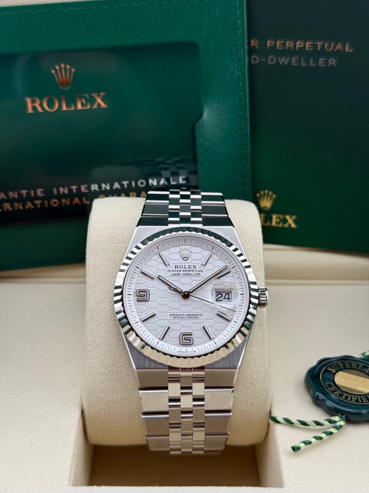 Rolex Land-Dweller 137334 - watch in a display case with green Rolex box in the background